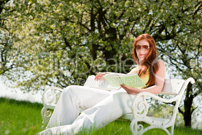 Young woman relaxing under blossom tree in spring