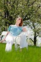 Young woman relaxing under blossom tree in spring