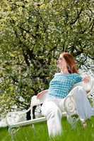 Young woman relaxing under blossom tree in spring