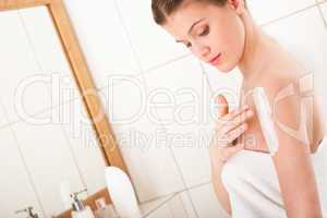Body care series - Young woman applying lotion