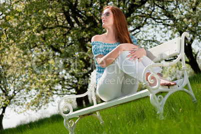 Young woman relaxing under blossom tree in spring