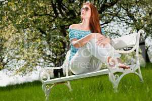 Young woman relaxing under blossom tree in spring