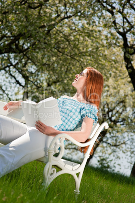 Young woman relaxing under blossom tree in spring