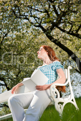 Young woman relaxing under blossom tree in spring