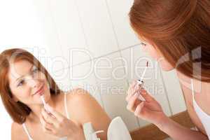 Body care series - Smiling attractive woman applying lipstick