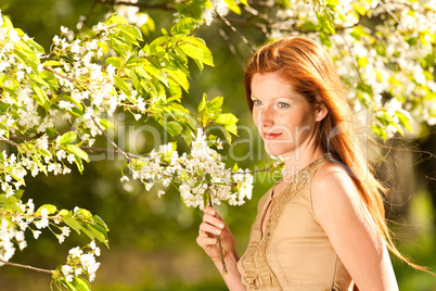 Young woman enjoying spring under blossom tree