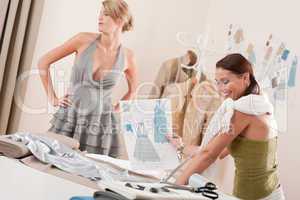 Fashion model fitting dress by professional designer