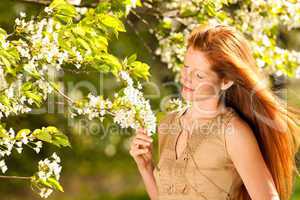 Young woman enjoying spring under blossom tree