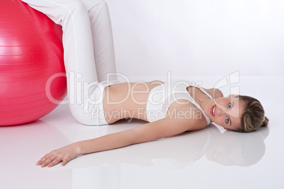 Fitness - Young woman with exercise ball on white