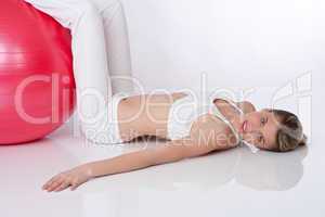 Fitness - Young woman with exercise ball on white