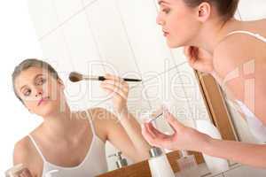 Body care woman - Applying powder in front of the mirror