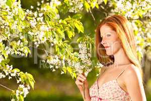 Young woman enjoying spring under blossom tree