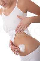 Body care series - Woman applying cream on  her belly