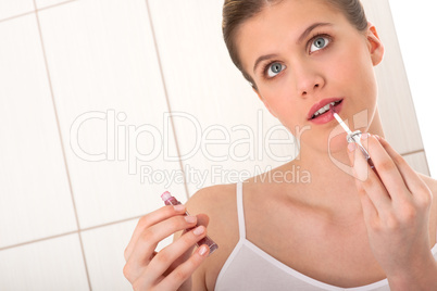 Body care series - Young woman applying lipstick