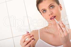 Body care series - Young woman applying lipstick