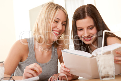 Student series - Two smiling girls watching book