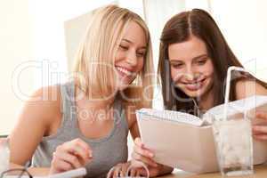 Student series - Two smiling girls watching book