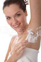 Body care series - Smiling woman shaving her armpit