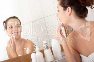 Body care series - Young woman cleaning her face in the bathroom