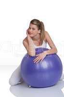 Fitness - Young woman with exercise ball on white