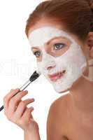 Body care series - Young woman applying white facial mask