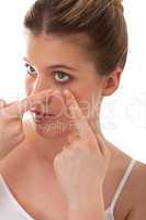 Body care - young woman applying contact lens
