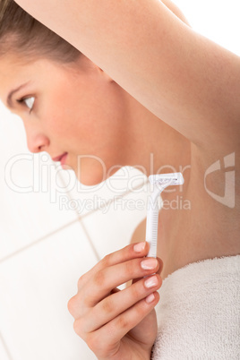 Body care series -Young woman shaving her armpit