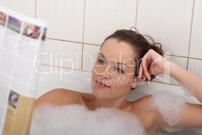 Body care series - Young woman with magazine in the bathtub