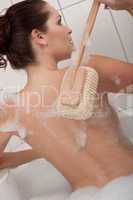 Body care series - Woman cleaning her back using sponge