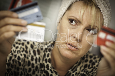 Upset Woman Glaring At Her Many Credit Cards.