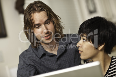 Happy Young Man and Woman Using Laptop Together