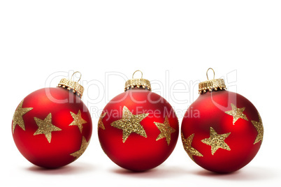 drei matte rote christbaumkugeln mit roten glittersternen