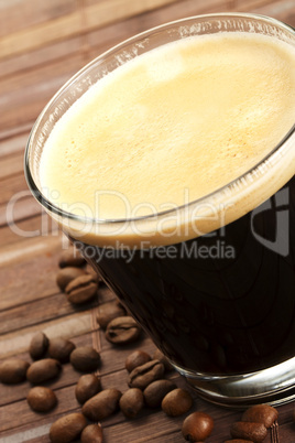 espresso in einem kleinen glas mit kaffeebohnen