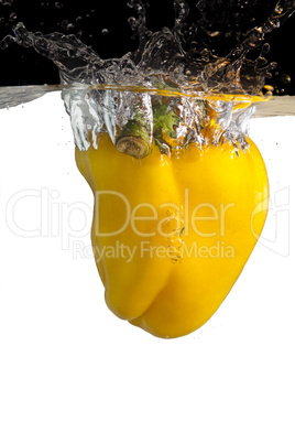 Gelber Paprika fällt ins Wasser
