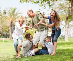 Family holding back grandfather and having fun