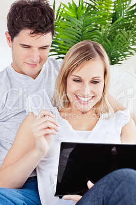 couple using laptop siting on a sofa