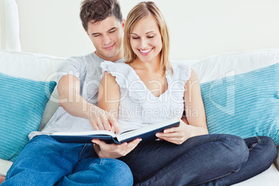 loving couple reading a book on the sofa
