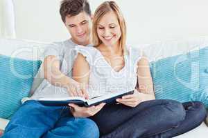 loving couple reading a book on the sofa