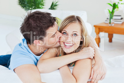 man kissing his joyful girlfriend