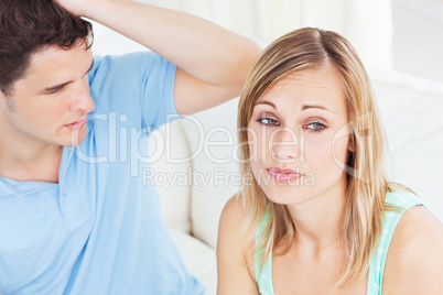 Young couple having a talk sitting on a sofa