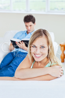 Girlfriend smiling at the camera while her boyfriend is focused