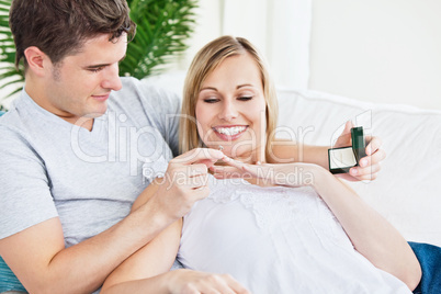 man putting a wedding ring on his girlfriend