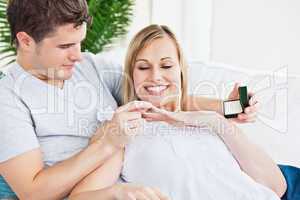 man putting a wedding ring on his girlfriend