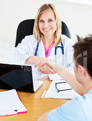 Smiling doctor shaking the hand of her patient