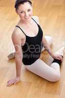 Young ballerina stretching on the floor