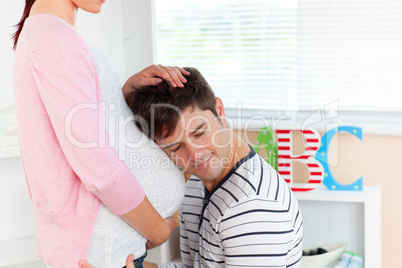 man listening to the belly of his pregnant wife