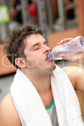 man drinking water with towel