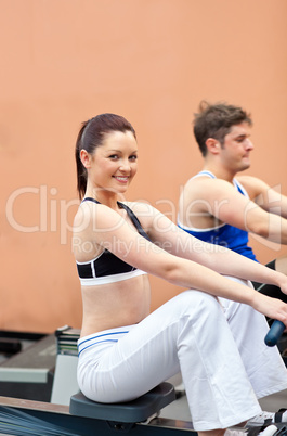 people using a rower in a fitness center