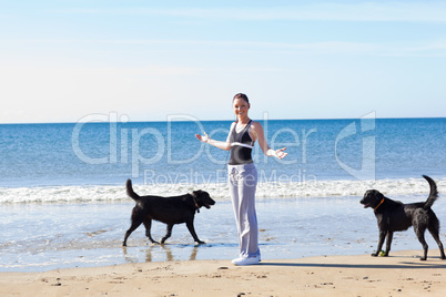 Frau mit Hunden am Strand