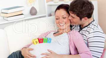 young man kissing his pregnant wife